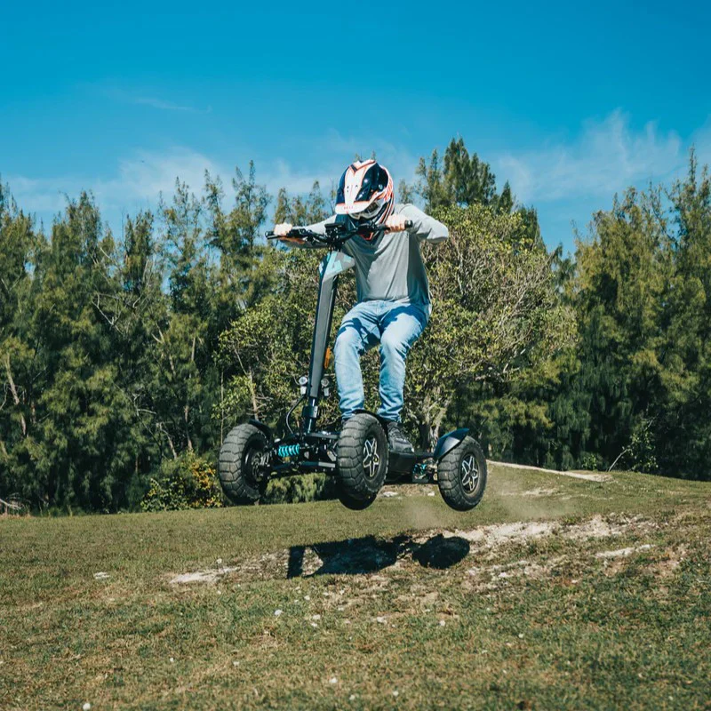 Action shot of a rider jumping the MIA Four X2 scooter off the ground in an off road setting