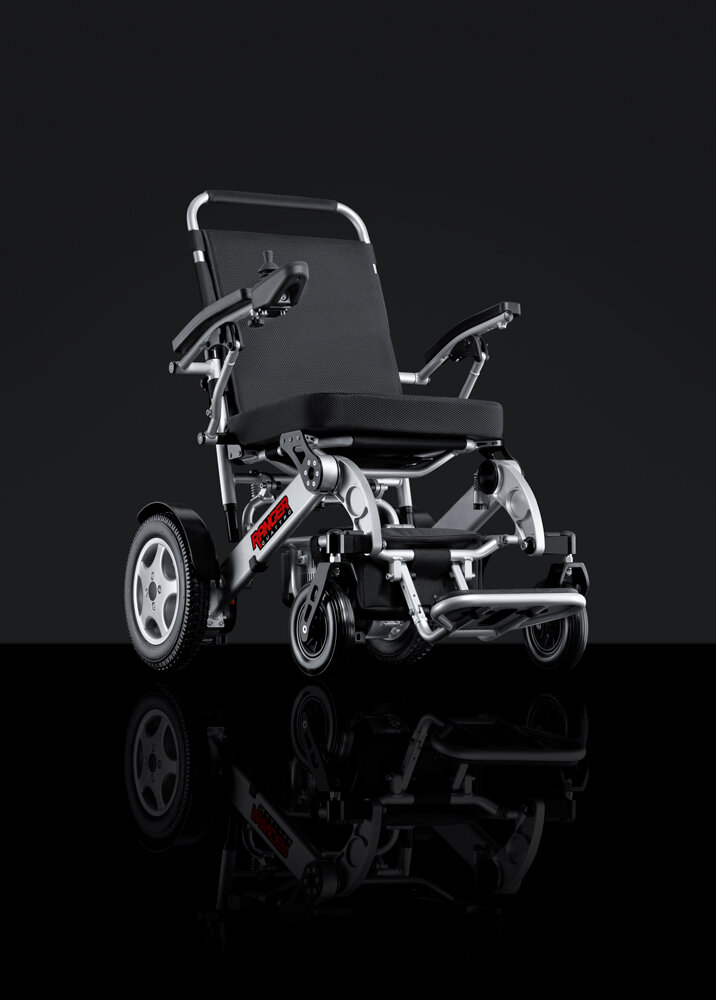 Porto Mobility Ranger Quattro XXL folding power wheelchair, angled front view on a dark reflective background